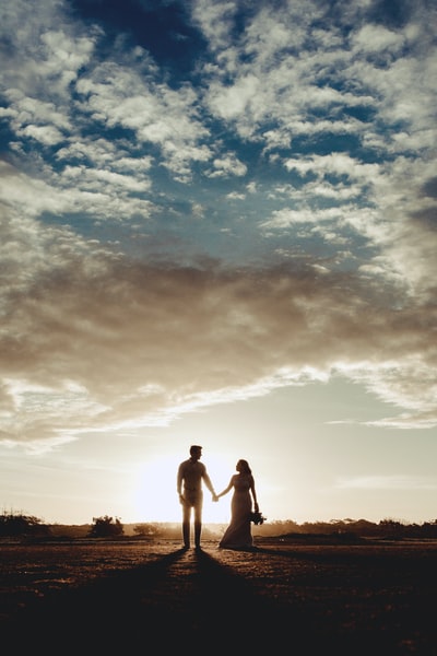 剪影照片的男人和女人在湛蓝的天空下
